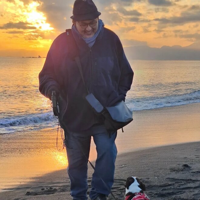 夕日をバックに海辺を散歩する貴乃花と犬