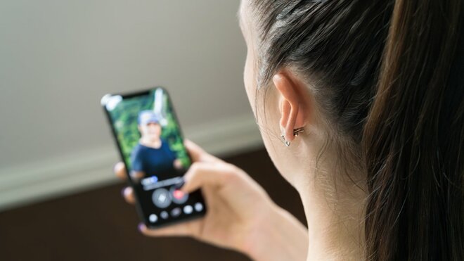 スマホの着信画面を見る女性