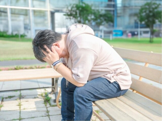 頭を抱えて悩む男