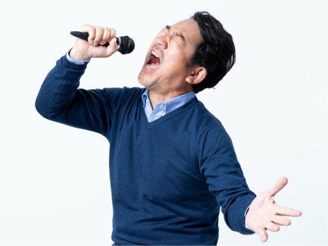 マイクを独り占めして唄う男性